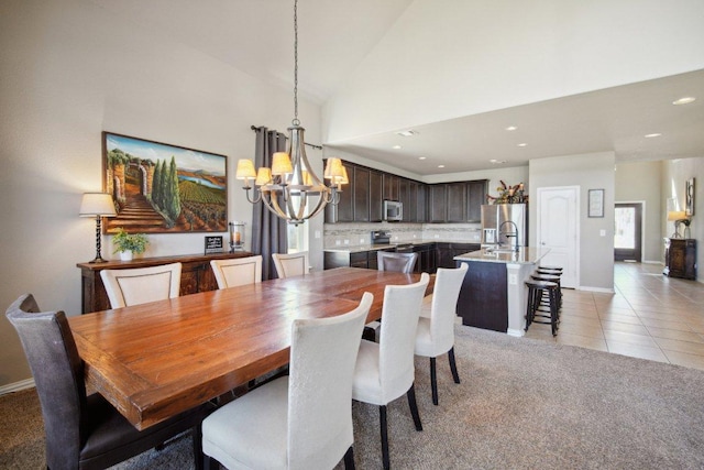 dining area featuring light carpet, light tile patterned floors, baseboards, high vaulted ceiling, and a notable chandelier