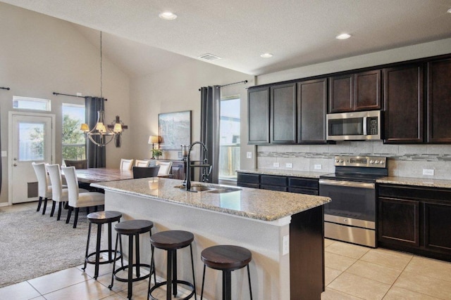 kitchen featuring stainless steel appliances, a wealth of natural light, visible vents, a sink, and a kitchen breakfast bar