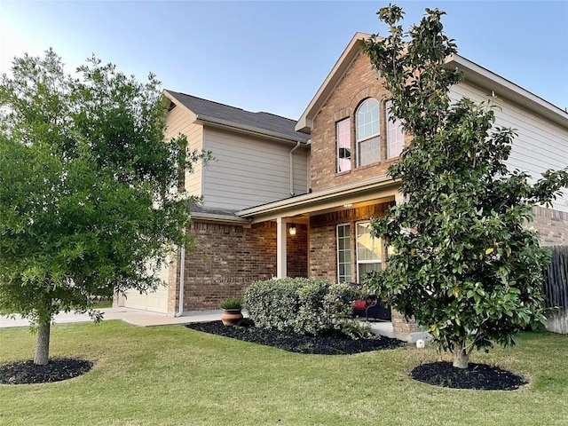 1010 Papaya Cv, Hutto, TX 78634 - traditional home with brick siding, a front lawn, and a garage