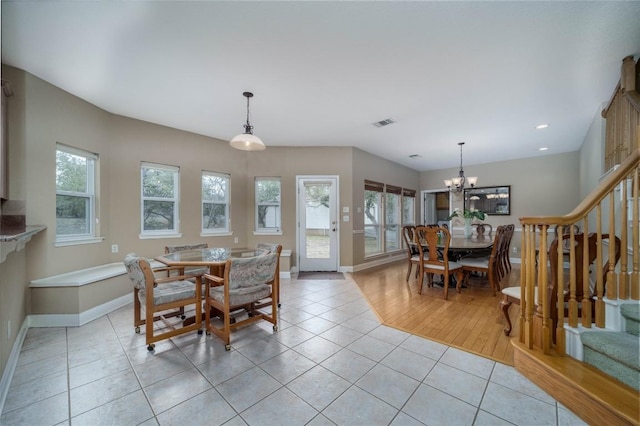 dining area featuring light tile patterned floors, stairs, visible vents, and a healthy amount of sunlight