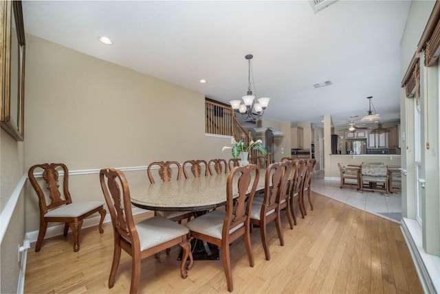 dining space with light wood finished floors, recessed lighting, visible vents, and an inviting chandelier