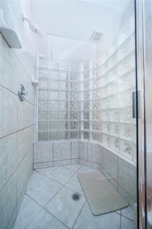 bathroom featuring visible vents and a tile shower