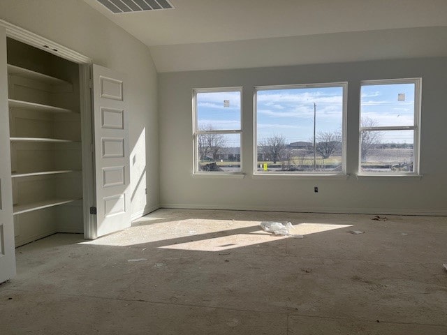 empty room with vaulted ceiling and visible vents