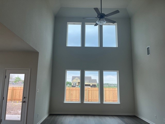503 Ansley Ct, Taylor, TX 76574 - unfurnished living room with a high ceiling, wood finished floors, ceiling fan, and baseboards