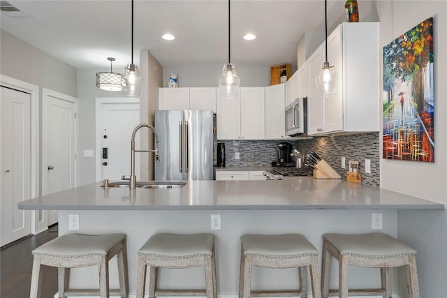 kitchen with white cabinets, appliances with stainless steel finishes, visible vents, and tasteful backsplash