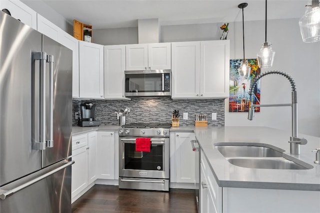 kitchen featuring dark wood finished floors, high end appliances, light countertops, decorative backsplash, and a sink