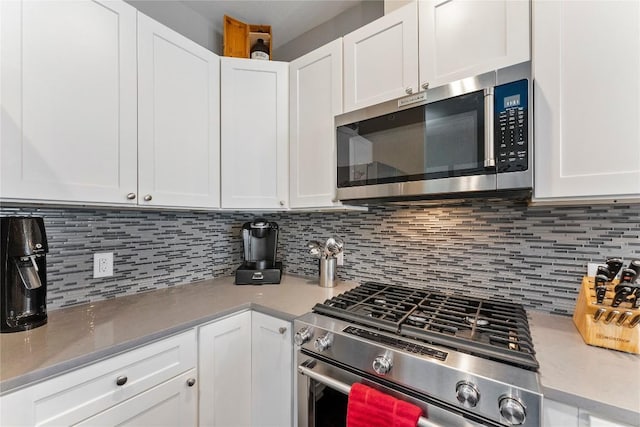 kitchen with light countertops, appliances with stainless steel finishes, decorative backsplash, and white cabinets