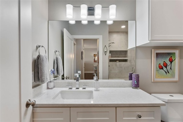 full bathroom featuring toilet, tiled shower, and vanity