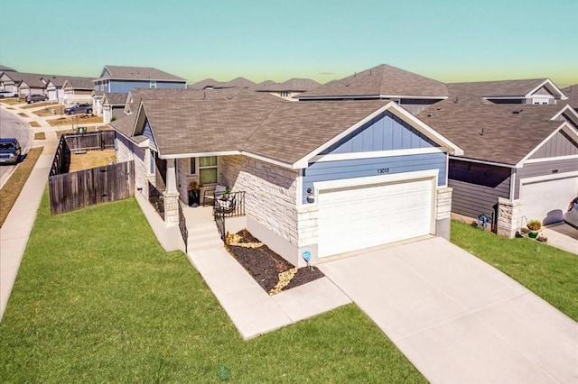 view of front of property with an attached garage, fence, concrete driveway, a front lawn, and board and batten siding