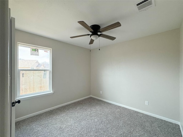 carpeted empty room featuring visible vents, baseboards, and ceiling fan