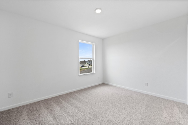 unfurnished room with carpet floors and baseboards