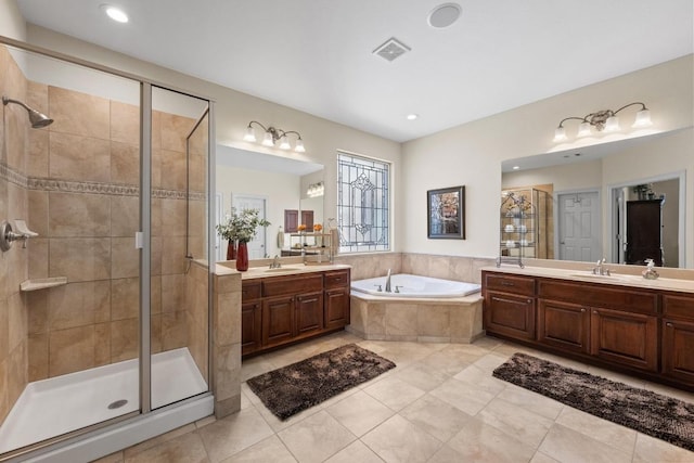 bathroom featuring a stall shower, visible vents, a sink, a garden tub, and two vanities