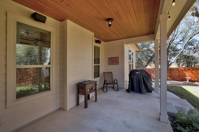 view of patio featuring a grill and fence