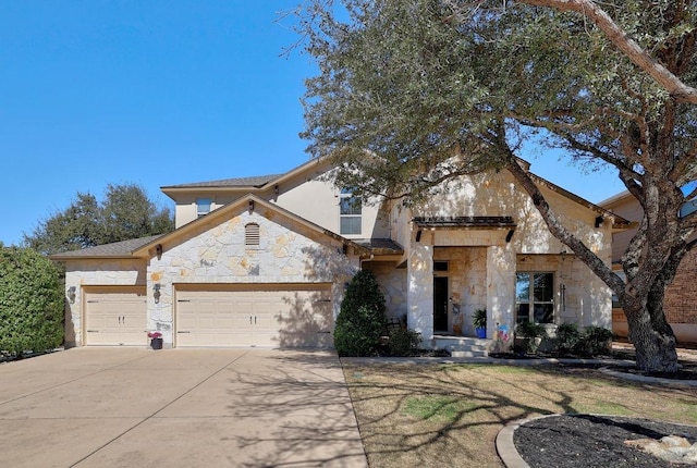 view of front of property featuring stone siding, an attached garage, and concrete driveway