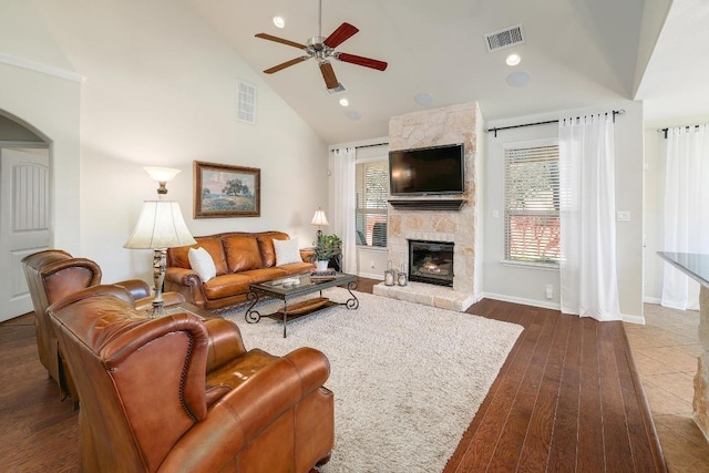 living room featuring high vaulted ceiling, dark wood finished floors, visible vents, and a fireplace