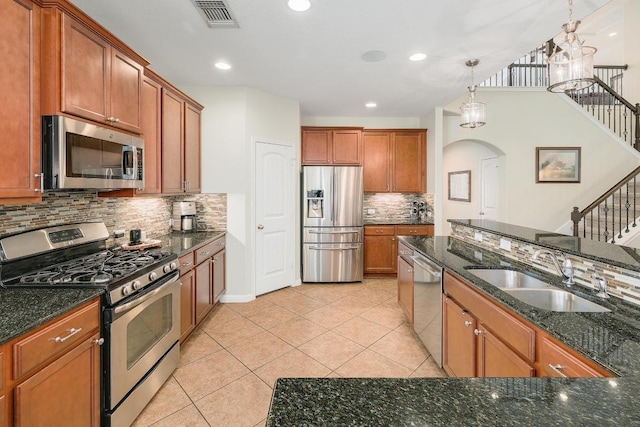 kitchen featuring visible vents, arched walkways, appliances with stainless steel finishes, a sink, and light tile patterned flooring