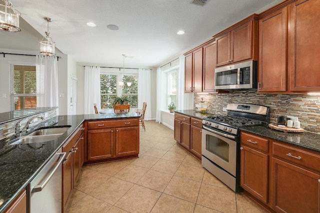 kitchen featuring tasteful backsplash, appliances with stainless steel finishes, a sink, and light tile patterned flooring