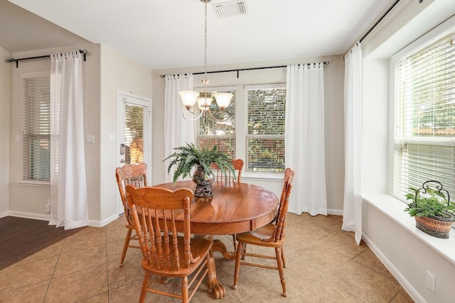 dining area featuring light tile patterned floors, visible vents, baseboards, and an inviting chandelier