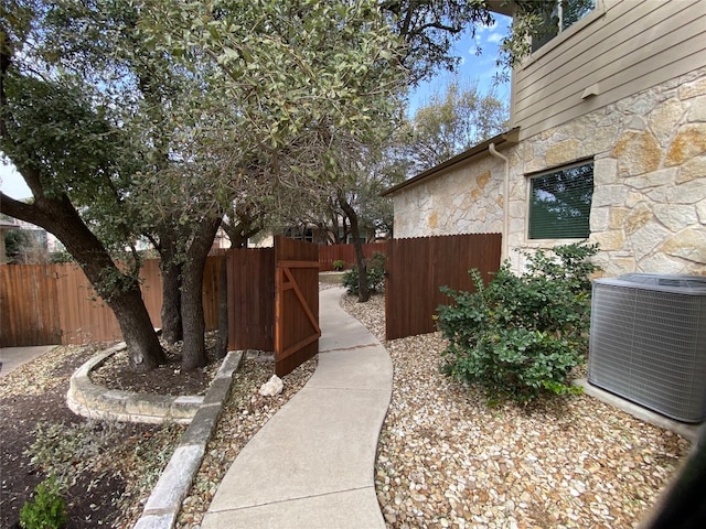 view of yard featuring central AC and fence