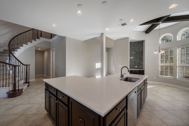 kitchen with light countertops, visible vents, stainless steel dishwasher, a sink, and an island with sink