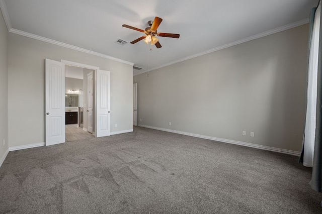 unfurnished bedroom featuring baseboards, visible vents, connected bathroom, crown molding, and carpet floors