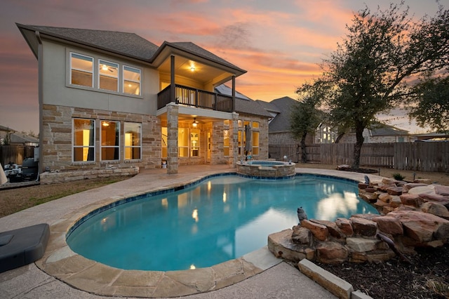 view of swimming pool with ceiling fan, a patio, fence, and a pool with connected hot tub