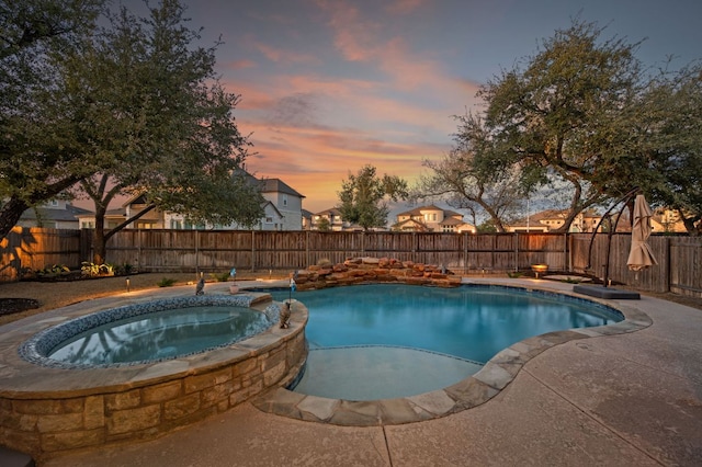 view of pool featuring a pool with connected hot tub and a fenced backyard