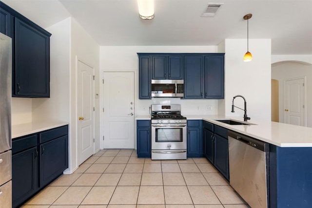 kitchen featuring visible vents, appliances with stainless steel finishes, a peninsula, blue cabinetry, and a sink