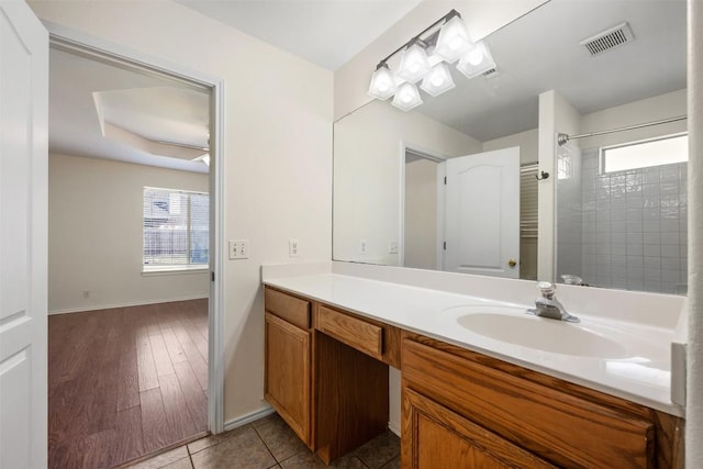 full bath with a shower, visible vents, vanity, baseboards, and tile patterned floors