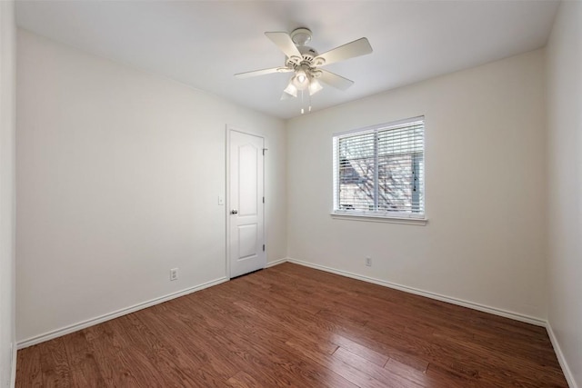 empty room with a ceiling fan, baseboards, and wood finished floors