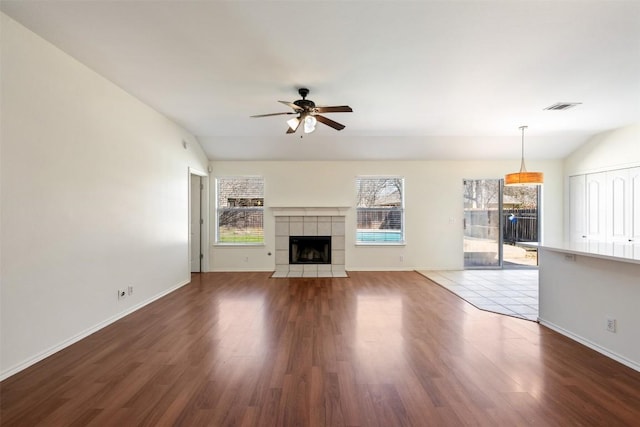 unfurnished living room featuring lofted ceiling, wood finished floors, visible vents, and a ceiling fan