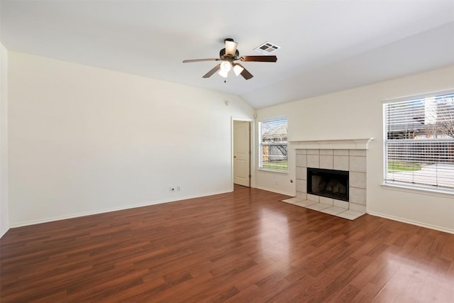 unfurnished living room featuring ceiling fan, lofted ceiling, a fireplace, wood finished floors, and visible vents