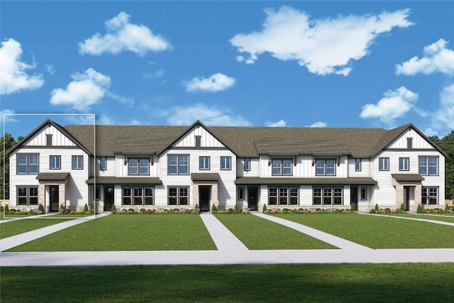 view of front of property with board and batten siding, stone siding, and a front lawn