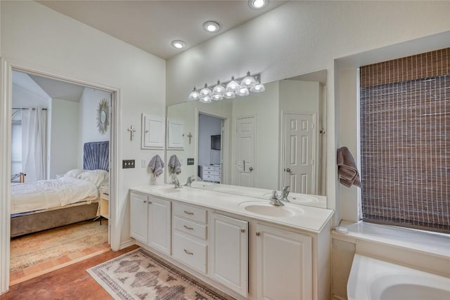 ensuite bathroom with ensuite bathroom, double vanity, a sink, and recessed lighting