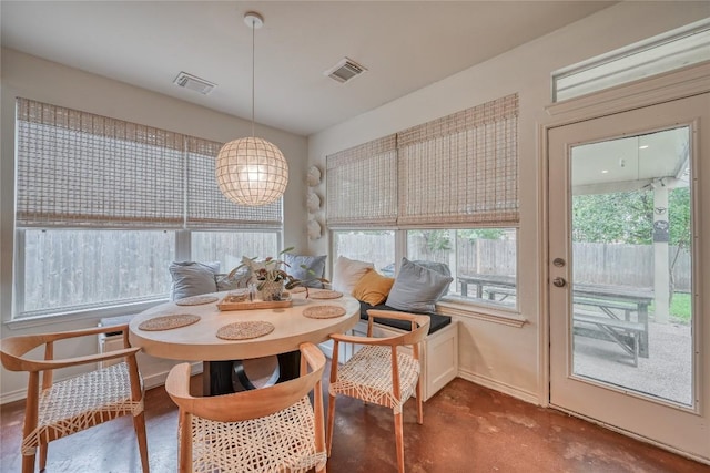 dining room featuring concrete flooring, visible vents, and baseboards