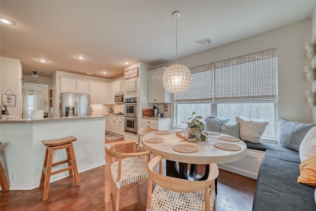 dining space featuring finished concrete flooring, visible vents, and recessed lighting