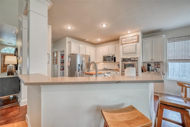 kitchen featuring a sink, white cabinets, stainless steel appliances, and backsplash