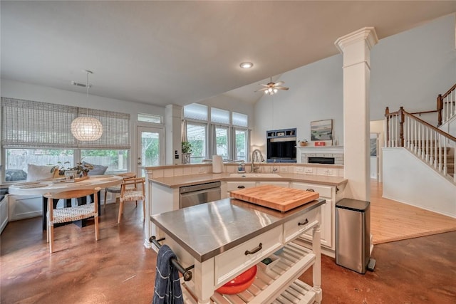 kitchen with a sink, stainless steel counters, concrete flooring, and stainless steel dishwasher