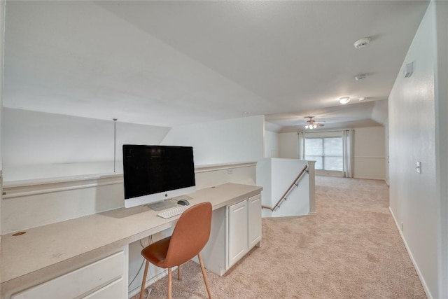 office area with light colored carpet, built in desk, and baseboards