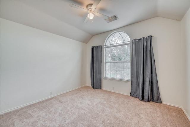 spare room with lofted ceiling, carpet floors, ceiling fan, and visible vents