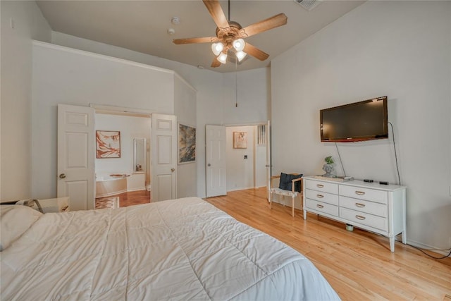 bedroom featuring light wood-style flooring, a high ceiling, and ceiling fan