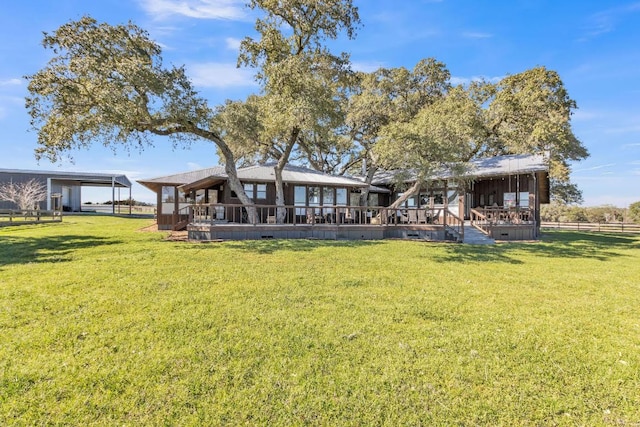 back of house featuring a carport, a wooden deck, a yard, and fence