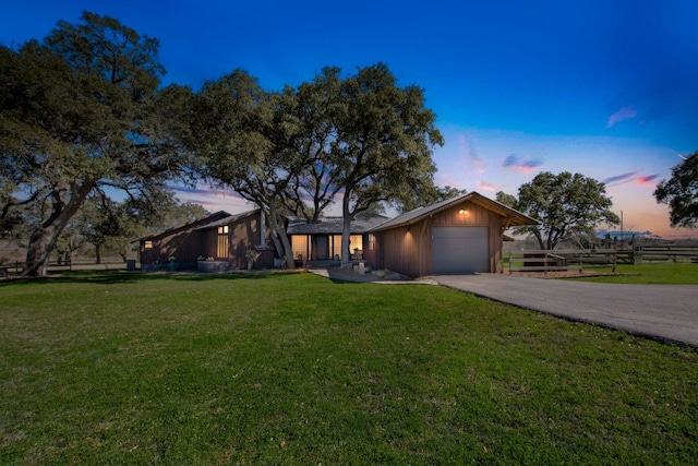 mid-century home featuring fence, a lawn, a garage, and driveway