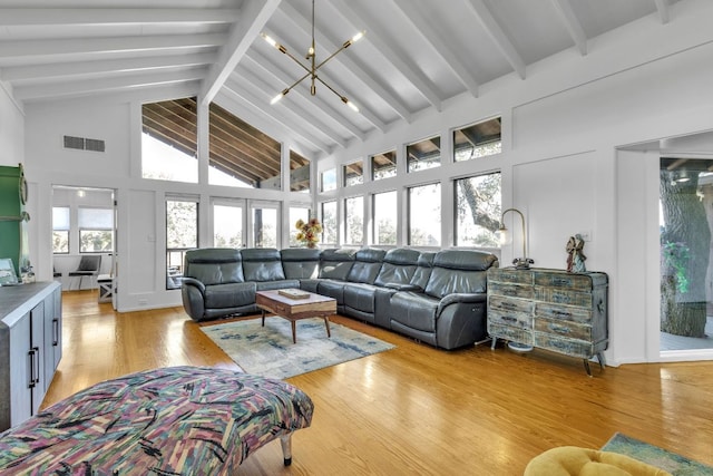 living area featuring visible vents, beamed ceiling, high vaulted ceiling, and light wood-type flooring