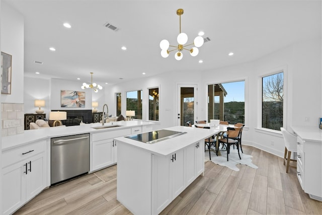 kitchen featuring a notable chandelier, black electric stovetop, visible vents, stainless steel dishwasher, and a sink