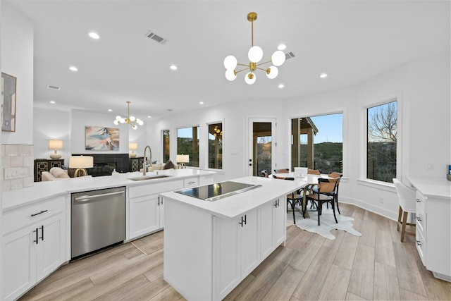 kitchen featuring visible vents, black electric cooktop, a chandelier, a sink, and dishwasher