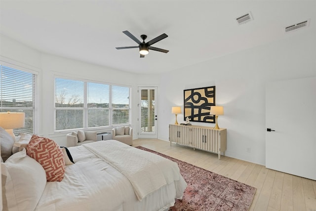 bedroom featuring ceiling fan, visible vents, access to exterior, and hardwood / wood-style flooring