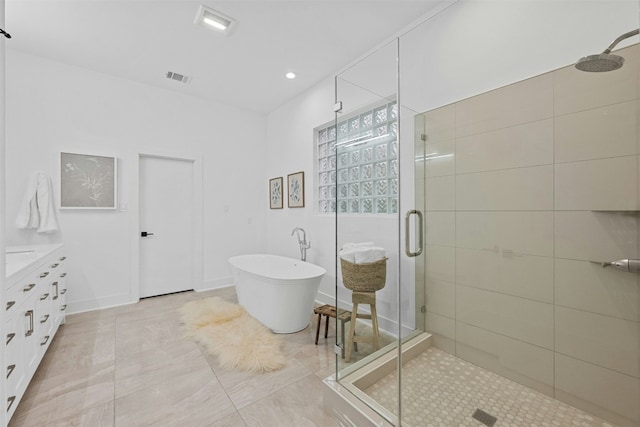 bathroom with visible vents, a freestanding bath, a stall shower, vanity, and baseboards