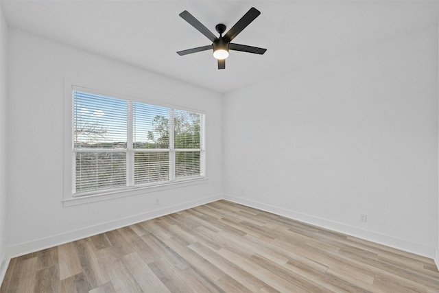 spare room featuring light wood-style flooring, baseboards, and ceiling fan