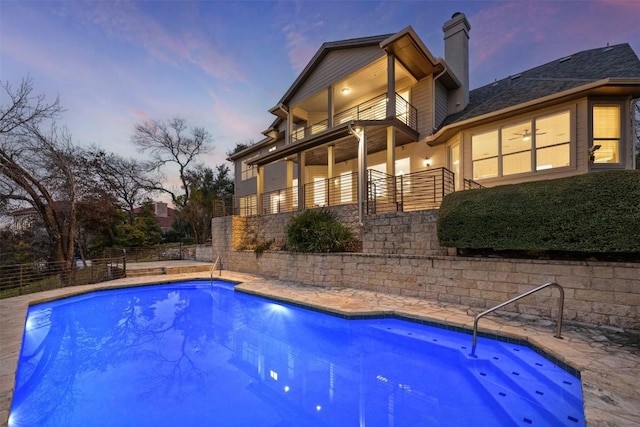 pool at dusk featuring fence and a fenced in pool